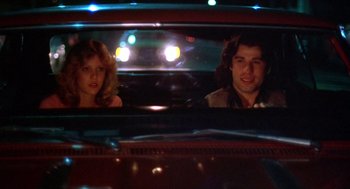 Movie still from “Carrie” (1976), directed by Brian De Palma – A man and a woman in the back seat of a car; Medium shot, Low angle