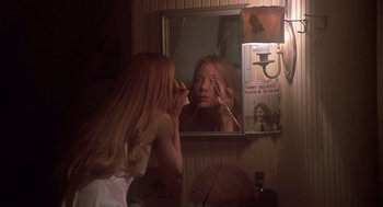 Movie still from “Carrie” (1976), directed by Brian De Palma – A woman looking in the mirror in front of a mirror; Close Up shot, Over the shoulder angle