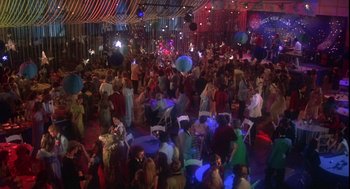 Movie still from “Carrie” (1976), directed by Brian De Palma – A large group of people in a room with lights; Extreme Wide shot, High angle