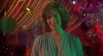 Movie still from “Carrie” (1976), directed by Brian De Palma – A woman in a green dress smiling for the camera; Close Up shot, Low angle