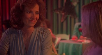 Movie still from “Carrie” (1976), directed by Brian De Palma – A woman sitting at a table in front of other people; Close Up shot, Over the shoulder angle