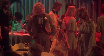 Movie still from “Carrie” (1976), directed by Brian De Palma – A group of people standing in a room; Medium shot, High angle