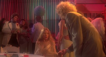 Movie still from “Carrie” (1976), directed by Brian De Palma – A woman sitting at a table in front of another woman; Medium shot, Over the shoulder angle