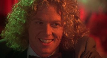 Movie still from “Carrie” (1976), directed by Brian De Palma – A person with curly blonde hair; Close Up shot, Over the shoulder angle