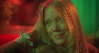 Movie still from “Carrie” (1976), directed by Brian De Palma – A woman with long blonde hair smiling at the camera; Close Up shot, Low angle