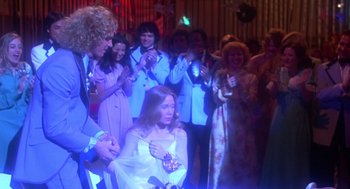 Movie still from “Carrie” (1976), directed by Brian De Palma – A group of people in a room with lights; Medium shot, Over the shoulder angle