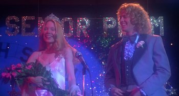 Movie still from “Carrie” (1976), directed by Brian De Palma – A man and a woman are standing in front of a microphone; Medium shot, Low angle