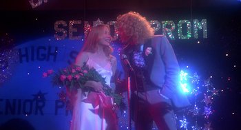 Movie still from “Carrie” (1976), directed by Brian De Palma – A man and a woman are standing on a stage; Medium shot, Low angle