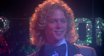 Movie still from “Carrie” (1976), directed by Brian De Palma – A person wearing a suit and bow tie; Close Up shot, Low angle