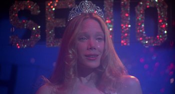 Movie still from “Carrie” (1976), directed by Brian De Palma – A woman with long blonde hair wearing a tiara; Close Up shot, Low angle