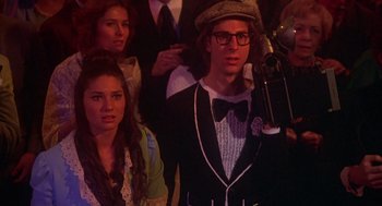 Movie still from “Carrie” (1976), directed by Brian De Palma – A group of people standing in front of a camera; Medium shot, High angle