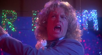 Movie still from “Carrie” (1976), directed by Brian De Palma – A man with curly blonde hair is yelling; Close Up shot, Low angle
