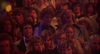 Movie still from “Carrie” (1976), directed by Brian De Palma – A group of people sitting in a room; Medium shot, High angle