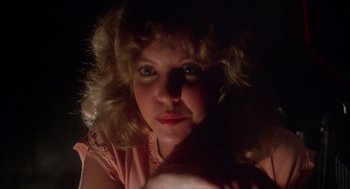 Movie still from “Carrie” (1976), directed by Brian De Palma – A woman with blonde curly hair is holding a ball in her hand; Close Up shot, Low angle