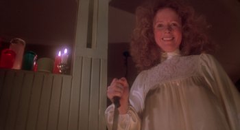 Movie still from “Carrie” (1976), directed by Brian De Palma – A woman holding a sword in front of a candle; Medium shot, Low angle