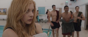 Movie still from “Carrie” (2013), directed by Kimberly Peirce – A woman sitting next to a swimming pool with other swimmers; Close Up shot, Over the shoulder angle