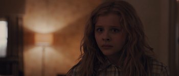 Movie still from “Carrie” (2013), directed by Kimberly Peirce – A girl with long red hair is looking at the camera; Close Up shot, Low angle