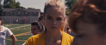 Movie still from “Carrie” (2013), directed by Kimberly Peirce – A young woman in a yellow jacket looking at the camera; Close Up shot, Over the shoulder angle