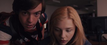 Movie still from “Carrie” (2013), directed by Kimberly Peirce – A young man standing next to a young woman; Close Up shot, Low angle