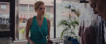 Movie still from “Carrie” (2013), directed by Kimberly Peirce – A woman in a blue dress looking out of a window; Medium shot, Over the shoulder angle