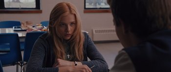 Movie still from “Carrie” (2013), directed by Kimberly Peirce – A woman sitting in front of a man with a pen in his hand; Medium shot, Over the shoulder angle