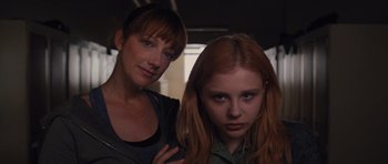 Movie still from “Carrie” (2013), directed by Kimberly Peirce – A woman standing next to a young girl; Close Up shot, Low angle