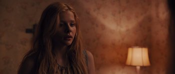 Movie still from “Carrie” (2013), directed by Kimberly Peirce – A girl with long red hair is looking into the distance; Close Up shot, Over the shoulder angle