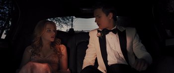 Movie still from “Carrie” (2013), directed by Kimberly Peirce – A man and a woman sitting in the back of a car; Medium shot, Low angle