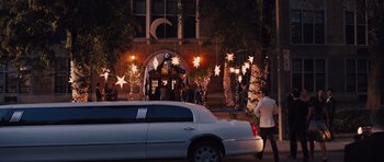 Movie still from “Carrie” (2013), directed by Kimberly Peirce – A limousine parked on the side of the street; Extreme Wide shot, Over the shoulder angle