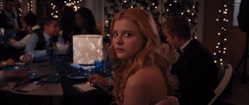 Movie still from “Carrie” (2013), directed by Kimberly Peirce – A young woman sitting in front of some lights; Close Up shot, Over the shoulder angle