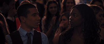 Movie still from “Carrie” (2013), directed by Kimberly Peirce – A man and a woman standing next to each other in front of a group of people; Close Up shot, Over the shoulder angle