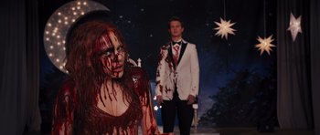 Movie still from “Carrie” (2013), directed by Kimberly Peirce – A man and a woman dressed as a bride and groom; Medium shot, Over the shoulder angle