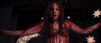 Movie still from “Carrie” (2013), directed by Kimberly Peirce – A woman with blood all over her face and body; Close Up shot, High angle