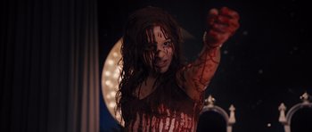 Movie still from “Carrie” (2013), directed by Kimberly Peirce – A woman with blood all over her face and body; Medium shot, High angle