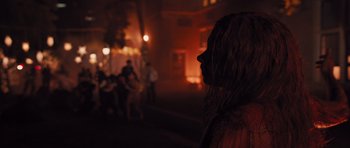 Movie still from “Carrie” (2013), directed by Kimberly Peirce – A woman in a crowd of people at night; Close Up shot, Over the shoulder angle