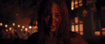 Movie still from “Carrie” (2013), directed by Kimberly Peirce – A young woman with red hair and makeup on her face; Close Up shot, High angle