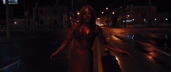 Movie still from “Carrie” (2013), directed by Kimberly Peirce – A woman with blood all over her face and body; Medium shot, Low angle