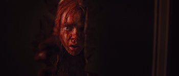Movie still from “Carrie” (2013), directed by Kimberly Peirce – A young girl with red hair and a face covered in blood; Close Up shot, Overhead angle