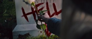 Movie still from “Carrie” (2013), directed by Kimberly Peirce – A hand holding a white rose in front of a grave; Extreme Close Up shot, High angle