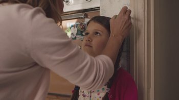 Movie still from “The Clovehitch Killer” (2018), directed by Duncan Skiles – A young girl getting her hair combed by an adult; Close Up shot, Over the shoulder angle