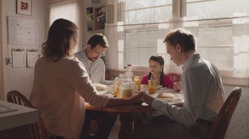 Movie still from “The Clovehitch Killer” (2018), directed by Duncan Skiles – A group of people sitting at a table with food; Medium shot, Low angle
