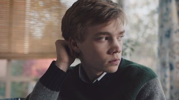 Movie still from “The Clovehitch Killer” (2018), directed by Duncan Skiles – A young man is looking out a window; Close Up shot, Low angle