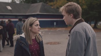 Movie still from “The Clovehitch Killer” (2018), directed by Duncan Skiles – A young man and a young woman standing next to each other; Medium shot, Over the shoulder angle