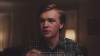 Movie still from “The Clovehitch Killer” (2018), directed by Duncan Skiles – A young man in a green and white plaid shirt; Close Up shot, Over the shoulder angle