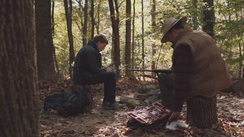 Movie still from “The Clovehitch Killer” (2018), directed by Duncan Skiles – Two men sitting on a bench in the woods; Wide shot, Over the shoulder angle