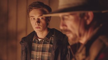 Movie still from “The Clovehitch Killer” (2018), directed by Duncan Skiles – A young man and an older man looking at each other in a mirror; Close Up shot, Over the shoulder angle