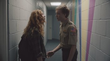 Movie still from “The Clovehitch Killer” (2018), directed by Duncan Skiles – A man and a woman are standing in a hallway; Medium shot, Over the shoulder angle