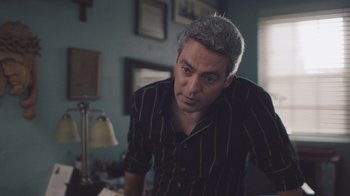 Movie still from “The Clovehitch Killer” (2018), directed by Duncan Skiles – A man in a black and brown striped shirt; Medium shot, Over the shoulder angle