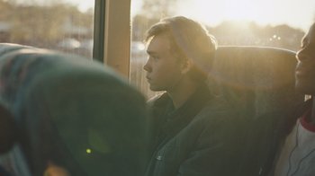 Movie still from “The Clovehitch Killer” (2018), directed by Duncan Skiles – A man sitting on a bus looking out the window; Close Up shot, Over the shoulder angle