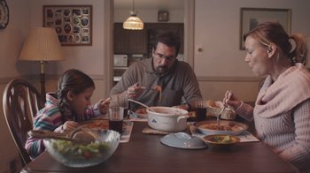 Movie still from “The Clovehitch Killer” (2018), directed by Duncan Skiles – A man sitting at a dinner table with two children; Medium shot, Over the shoulder angle